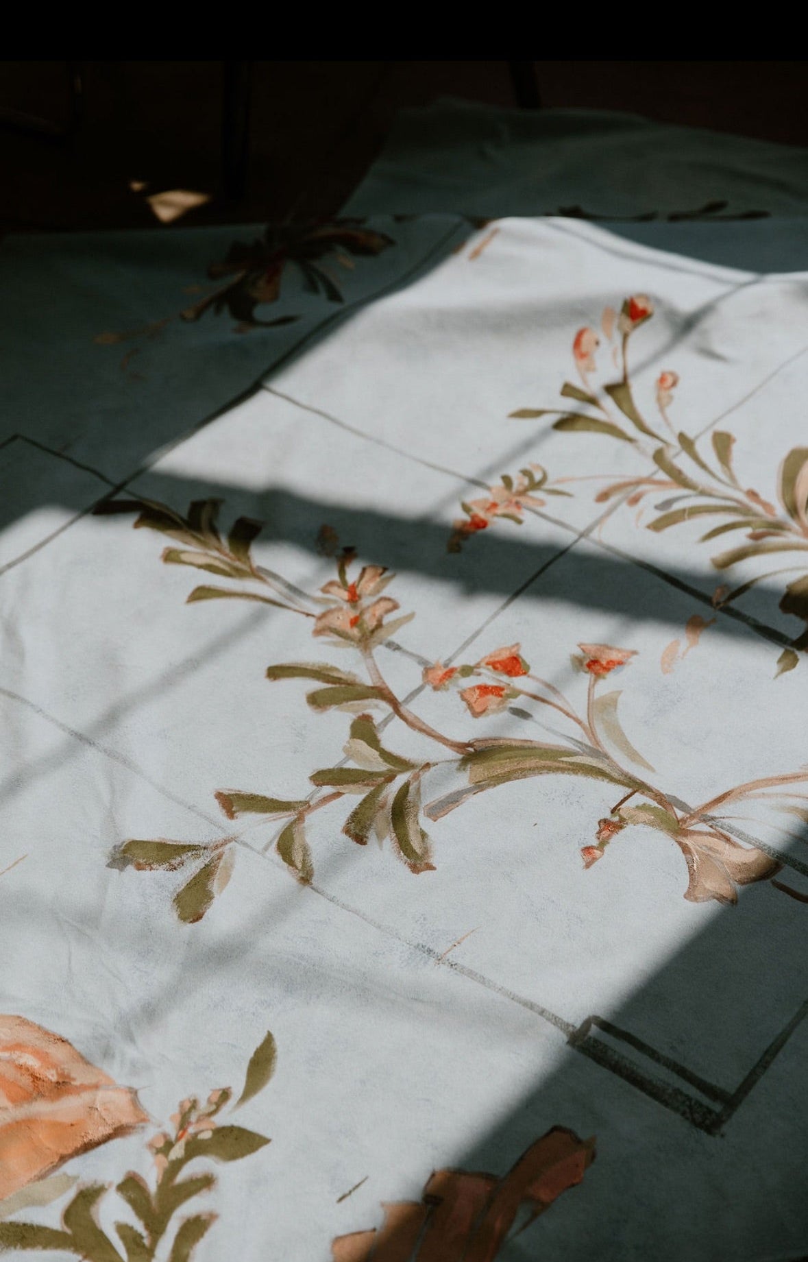 Floral patterned fabric on a tiled floor with shadows